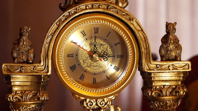 The arrows of the antique clock show 3:00.