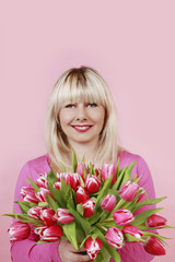 Glückliche Frau mit rosa Tulpenstrauss