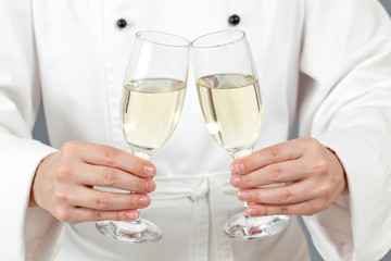 Woman chef holding two glasses of wine