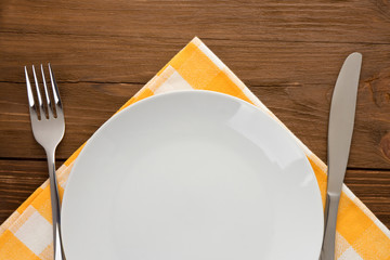 plate, knife and fork on wood