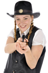 Junge Frau im Cowboy-Kostüm zielt mit Pistole