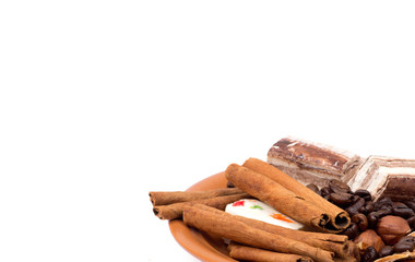 Sweets, cinnamon, nuts and coffee beans on a saucer