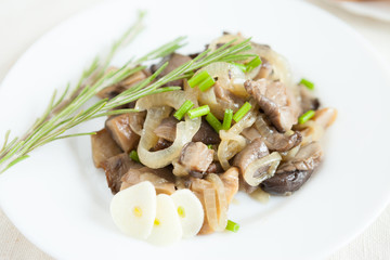 oyster mushrooms cooked with onions on a white dish