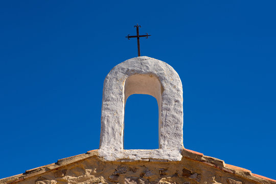 Christian cross on whitewashed arch at village church