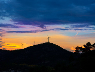 Sunset mountain with electric windmills