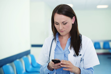 Fototapeta na wymiar Young female doctor texting