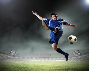 Foto op Plexiglas voetballer die de bal slaat © Sergey Nivens
