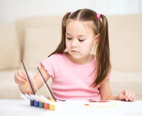 Cute cheerful child play with paints