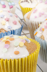 Cupcake mit verschieden farbigen Streuseln und weißem Zuckergus