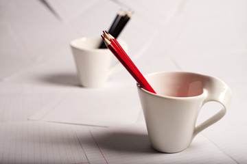 black and red pencils stand in two cups