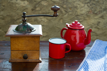 retro old coffee grinder with vintage red teapot