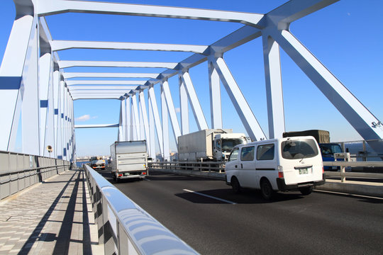 橋の上を走行する車とトラック