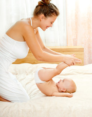 Obraz na płótnie Canvas Mother and daughter play in the bedroom