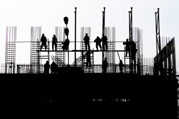 Silhouette of workers on a building in construction