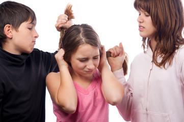 Teenagers pulling hair of smaller teenage girl