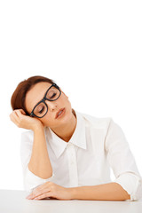 Bored businesswoman sleeping at her desk