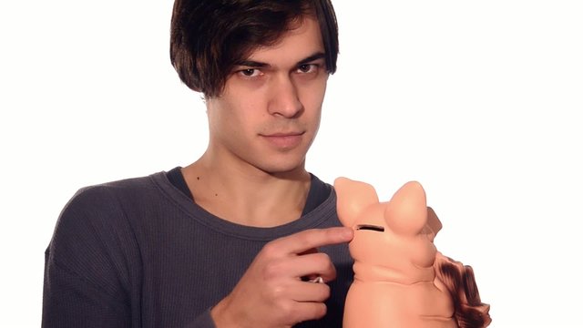 young man putting money in piggy bank