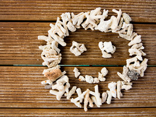 Smiling face made of pebbles over wooden plank