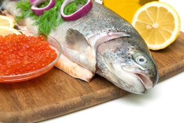 trout, red caviar in a glass bowl and lemon close up