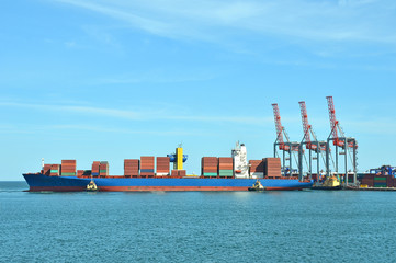 Container stack and ship under crane bridge
