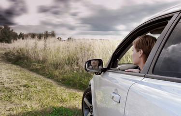 Woman driving car and looking on nature dark blue sky background