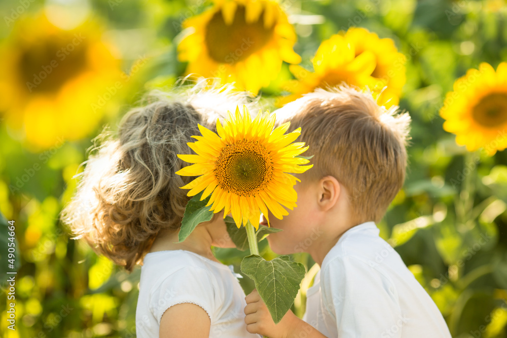 Poster children hiding by sunflower