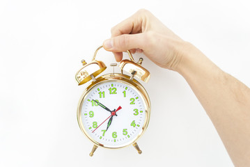 Alarm clock in a hand on a white background