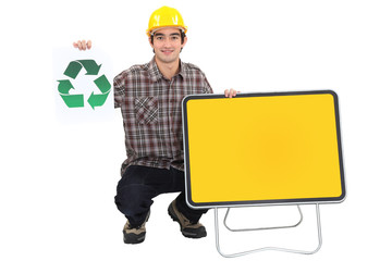 Young manual worker with recycle logo and blank road sign