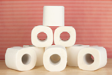 Rolls of toilet paper on striped red background