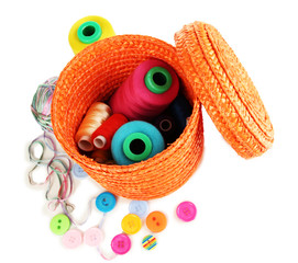 Orange wicker basket with accessories for needlework isolated