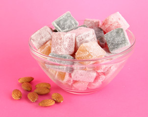 rahat lokum in plat and nuts on pink background