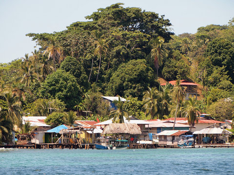 Village of Old Bank on the coast of Bastimentos island with lush tropical vegetation in background, Bocas del Toro, Panama, Central America