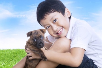 Obraz premium Happy boy and puppy outdoors