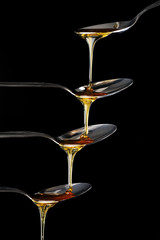 Golden honey spilling on dark background