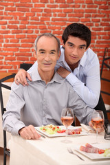 Father and son eating together in restaurant