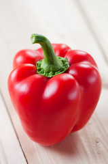 Red bell pepper on wooden boards, close-up, vertical shot