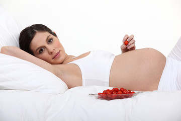 Obraz na płótnie Canvas Kobieta w ciąży z miską pomidorów