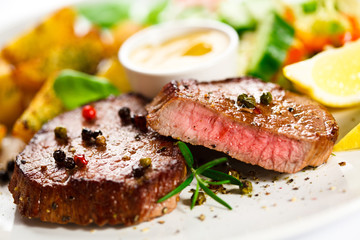 Grilled steak, baked potatoes and vegetables