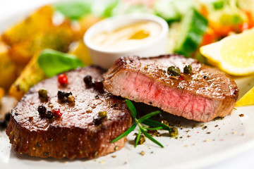 Grilled steak, baked potatoes and vegetables