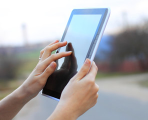 female hands holding a tablet touch computer