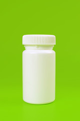 white pill bottle on green background