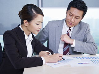 asian business people discussing sales performance