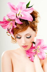 beautiful girl with pink lilies in her hair