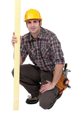 A kneeled male carpenter.