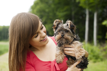 Smiling woman holding cute puppy © gpointstudio