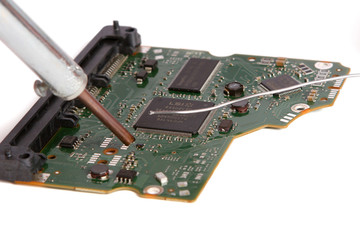 soldering iron in his hand on a white