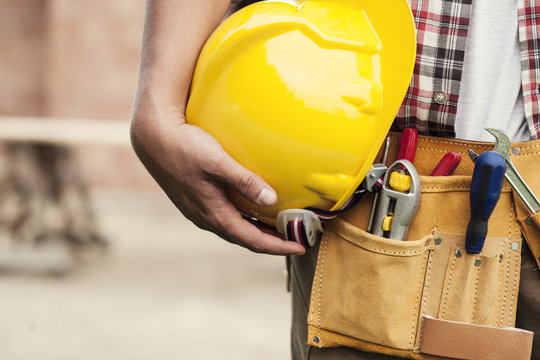 Close-up of hard hat holding by construction worker
