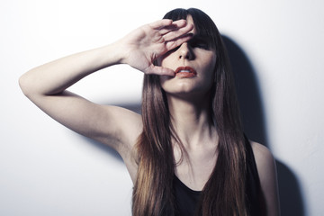 Close up of a young woman covering one eye with her hand