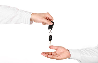 Male hand holding a car key and handing it over to another perso