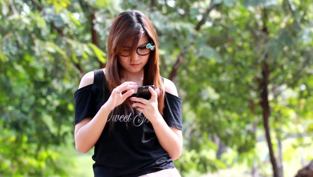 Woman outdoors texting on her mobile phon